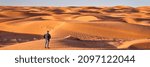 lonely male figure in a sand dunes field, dusty and windy morning in San Rafael Swell area in Utah (Lower San Rafael Road), panoramic web banner