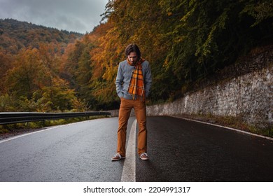 lonely man on road, concept of loneliness, depression, thoughtfulness. Autumn, mountains, beautiful background. Abstraction path to oneself, feeling of soul, cloudy bad weather.