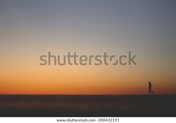 Lonely Man Walking Alone On Horizon Stock Photo Edit Now