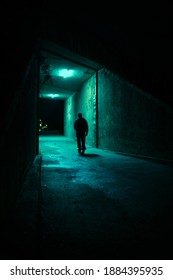 Lonely Man Walking In A Dark Alley At Night. Danger And Scary Concept.