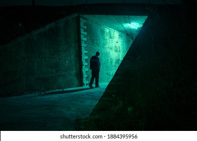 Lonely Man Walking In A Dark Alley At Night. Danger And Scary Concept.