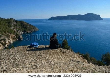 A lonely man watches the sea on the edge of the cliff. It can be used in studies with the theme of loneliness, solitude, sadness.