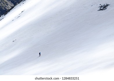Lonely mountaineer climbing snow covered mountain