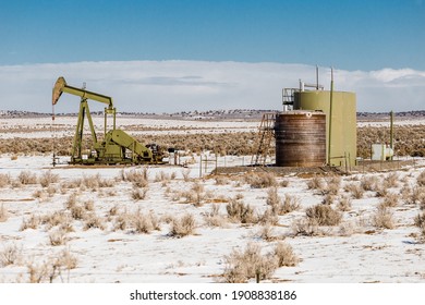 Lonely Oil Pump In The Middle Of A Snow Covered Desert Landscape On Clear Day In Rural New Mexico