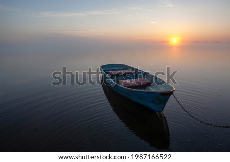 A lonely old boat on the very shore at sunrise