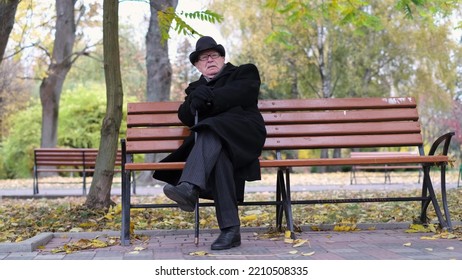 A Lonely Old Man Is Sitting On A Park Bench.