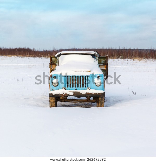 lonely\
old rusty truck under the snow in an open\
field