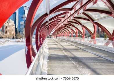 Lonely Person walking along a Pedestrian and Bicycle Bridge over a Frozen River