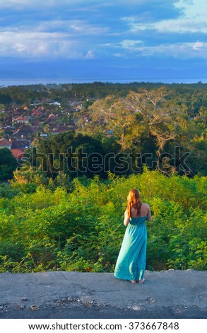 Lonely red-haired girl at sunset