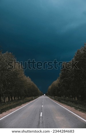 A lonely road in the summer before a threatening storm. Storm in summer. thunder clouds.