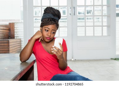 Lonely And Sad African American Woman Waiting For Message At Home