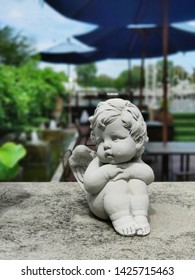 Lonely And Sad Cupid Statue Sit And Wait For A Love