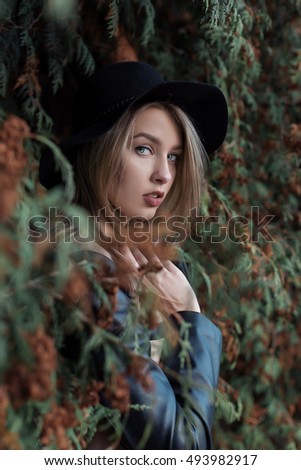 Similar – Portrait of smiling blonde woman with hat while she walks in nature looking into camera.