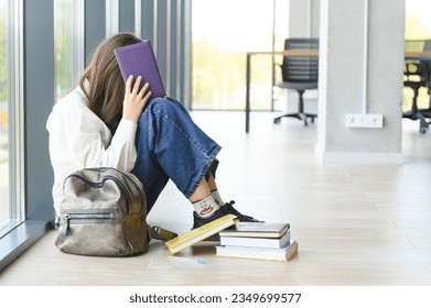 Lonely sad schoolgirl while all her classmates ignored her. Social exclusion problem. Bullying at school concept - Shutterstock ID 2349699577