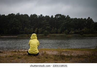 Lonely Sad Woman In Yellow Raincoat In Forest Under Rain, Back View