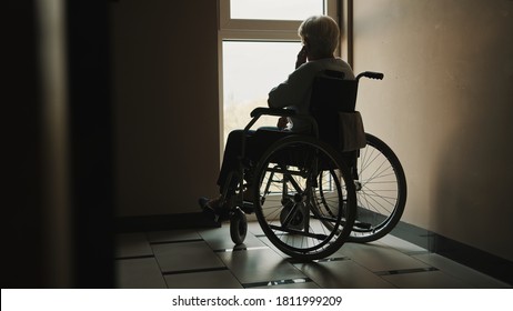 lonely senior woman looking through the window of the nursing home . High quality photo - Powered by Shutterstock