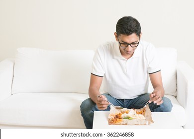 Lonely Single Asian Indian Man Eating Food Alone At Home, Copy Space At Side. Having Nasi Lemak As Lunch. 