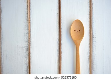 Lonely spoon on wood texture of dining table. Concept about loneliness and waiting for someone. (Copy Space)