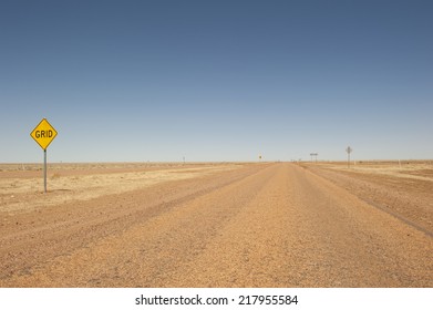 Lonely Straight Bitumen Road Towards Horizon In Outback Channel Country Of Queensland, Australia, Dry And Arid, With Blue Sky As Background And Copy Space.