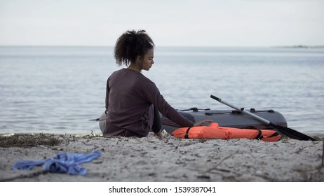 Lonely Teenage Girl Sitting Near Boat, Shipwreck Survivor On Desert Island