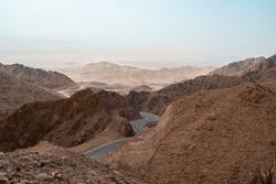 A Lonely Tiny Empty Road In The Middle Of Nowhere. An Endless Narrow Road Between The Mountains. Midlle East Nature. Curvy Scenic  Road In The Middle Of Jordan Desert.