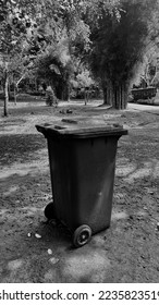 Lonely trash can in the empty park or backyard with black and white color