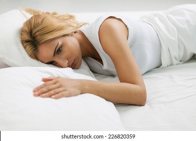 Lonely woman reaching for her husband in empty bedside. - Powered by Shutterstock