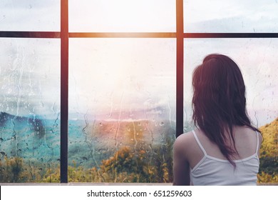 Lonely Woman Sitting In Front Of Window With Raining Outside