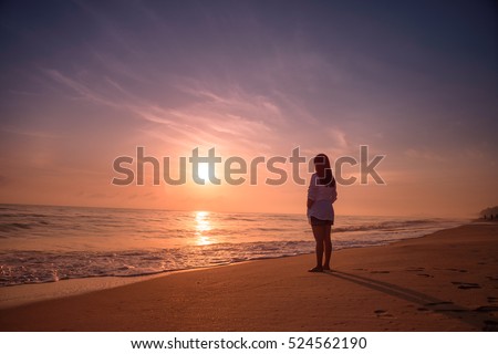 lonely woman standing on beach sunset の写真素材 今すぐ編集