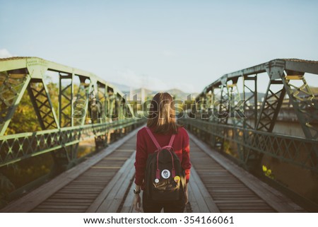 Lonely woman walking alone on the old iron bridge.