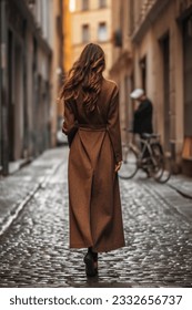 Mujer solitaria con un largo abrigo marrón. Estilo de calle de moda casual de otoño. Vista posterior