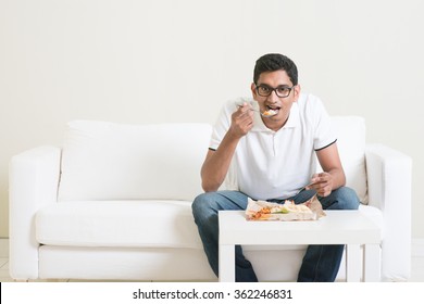 Lonely Young Single Indian Man Eating Food Alone, Copy Space At Side. Having Nasi Lemak As Lunch. Lifestyle Of Asian Guy At Home.