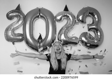 Lonely Young Woman Celebrating New Year 2023 At Home. Smiling Girl With Hands Up. Big Number Balloons.silvester Party. December 31.party Decoration. Confetti Falling. January 1.flower Wreath