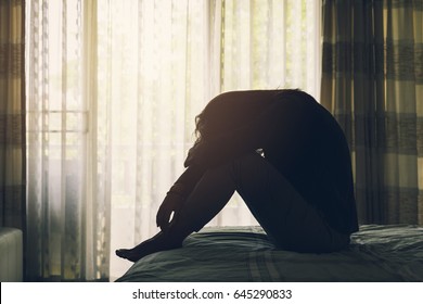 Lonely young woman feeling depressed and stressed sitting head in hands in the dark bedroom, Negative emotion and mental health concept
