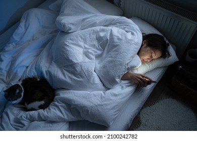 Lonely Young Woman Spend Night With Smartphone Lying Sleepless In Bed With Cat. Female Suffer From Depression, Apathy And Anxiety Avoid Communication With People, Addicted From Social Media And Gadget