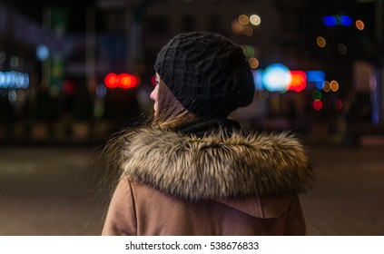 Lonely Young Woman Walking Through Night City Street