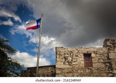 The Lonestar Flag Flies Over The Alamo, Originally Called Mission San Antonio De Valero, And Now A National Historic Landmark In Downtown San Antonio, Texas.