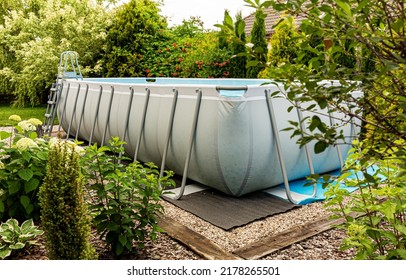Long, above ground, rectangular, rack (frame) swimming pool outdoor in the garden. Summer holiday (vacation) and recreation. - Shutterstock ID 2178265501