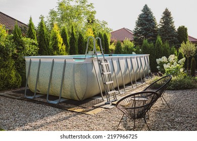 Long, Above Ground, Rectangular, Rack (frame) Swimming Pool Outdoor In The Pebble (gravel) Garden Nook. Summer Holiday (vacation) And Recreation.