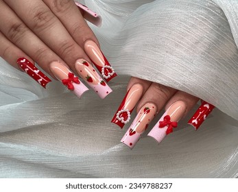 Long acrylic nails set pink French tip, red nail, strawberry design on nails. Professional nail art design