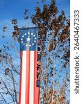 A long Amercan flag style banner with stars and stripes decorates a park near the Fourth of July