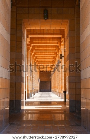 Long arcade corridor with ocre stone pillars in Sheikh Mohammed Bin Ibrahim Mosque in Riyadh, Saudi Arabia