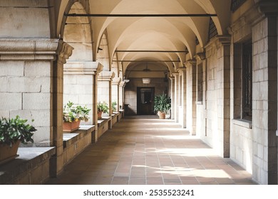 A long, arched stone corridor with columns and a tiled floor - Powered by Shutterstock