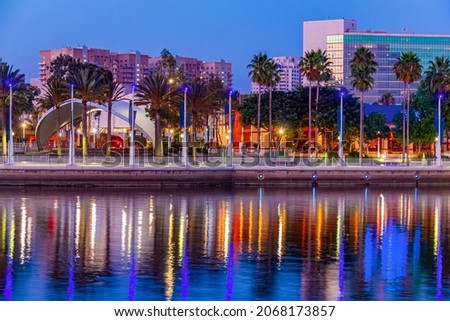  Long Beach, California skyline is reflected in the still water and the evening light creates a beautiful glow.