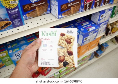 Long Beach, California/United States - 02/12/2020: A Hand Holds A Box Of Kashi Trail Mix Granola Bars On Display At A Local Grocery Store.