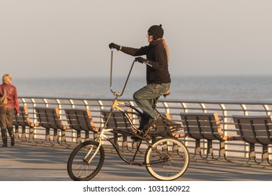 Long Beach, New York - 02/21/2018 : Man Riding An Oversized Tall Modified Beach Cruiser Bike On Long Beach Boardwalk.