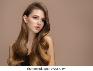 Long Beautiful Wavy Hair. Portrait Of A Woman On A Brown Background With Shiny Hair. Copycpase