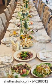 Long Beige Dinner Table Served With Delicious Dishes