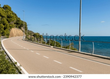 A long bike path overlooking the sea with no one around. Beautiful sunny day