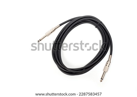 Long black jack cord for electric guitar, filmed on a white background.